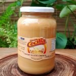 Doce de leite com nata da Doces Cecília, em pote de vidro com 700 gramas, sobre mesa de madeira.