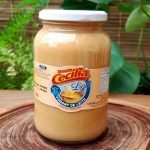 Doce de leite light da Doces Cecília, em pote de vidro com 700 gramas, sobre mesa de madeira.