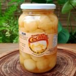 Doce de queijo em calda da Doces Cecília em pote de vidro com 700 gramas, sobre mesa de madeira.