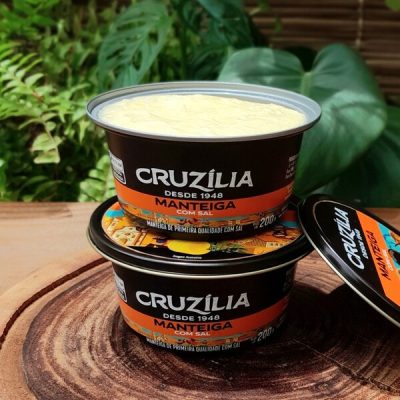 Manteiga Cruzília com sal em lata de 200 gramas sobre mesa de madeira.