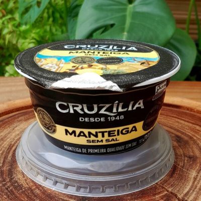 Manteiga Cruzilia sem sal em pote fechado com 200 gramas sobre mesa de madeira.