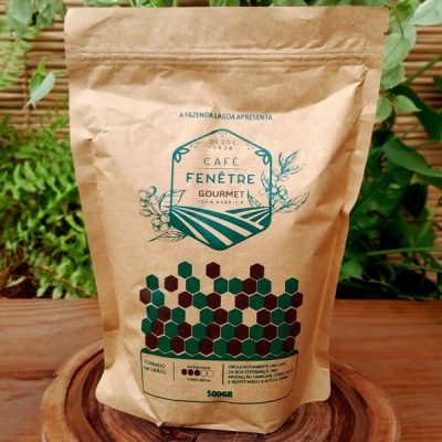 Café gourmet Fenêtre em grãos, em embalagem com 500 gramas sobre mesa de madeira.