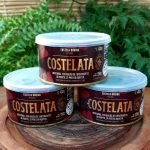 Costelata, a costela na lata em lata com 350 gramas, sobre mesa de madeira.