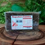 Rapadura de minas em barra de 550 gramas sobre mesa de madeira.