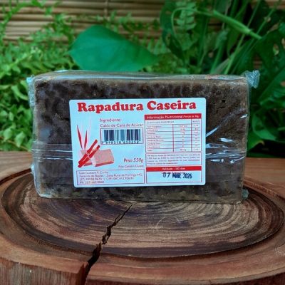 Rapadura de minas em barra de 550 gramas sobre mesa de madeira.