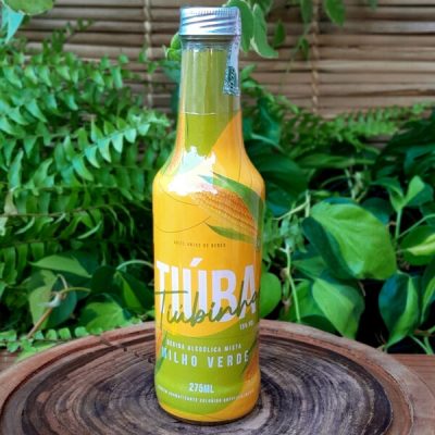 Tiúba milho verde em garrafa de 275 ml sobre mesa de madeira.