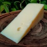A Lenda, queijo produzido pela queijaria Cruzília, sobre mesa de madeira.