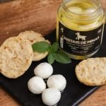 Queijo Boursin Minas Cabra em pote de vidro com 230 gramas, sobre mesa de madeira.