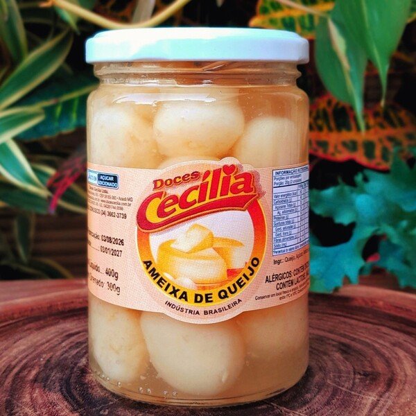 queijo-em-calda-doce Doce de queijo em calda Cecília em pote com 420 gramas sobre mesa de madeira.
